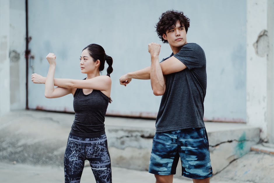 Young couple in activewear stretching outdoors, focused on fitness and health
