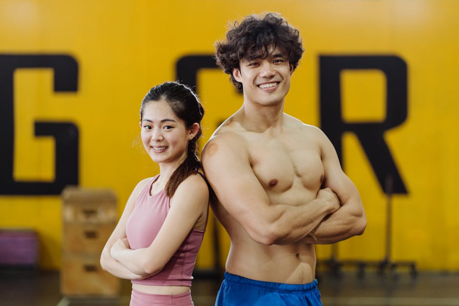 Smiling young man and woman in gym showcasing fitness and athleticism